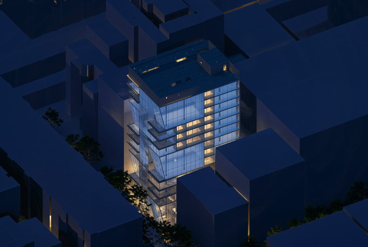 Aerial render at dusk: the tower glows with warm lit windows among dark neighbouring blocks
