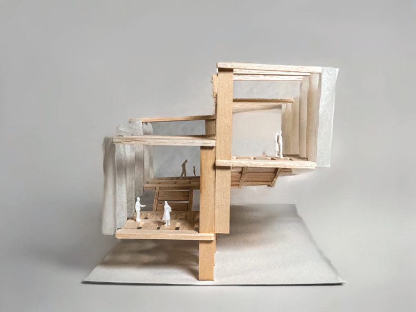 Balsa wood model of stacked cascading platforms with small figures standing on them