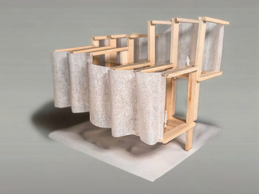 Balsa wood frame model with a long wavy ribbon of tracing paper wrapped along the facade and platforms stepping down behind it
