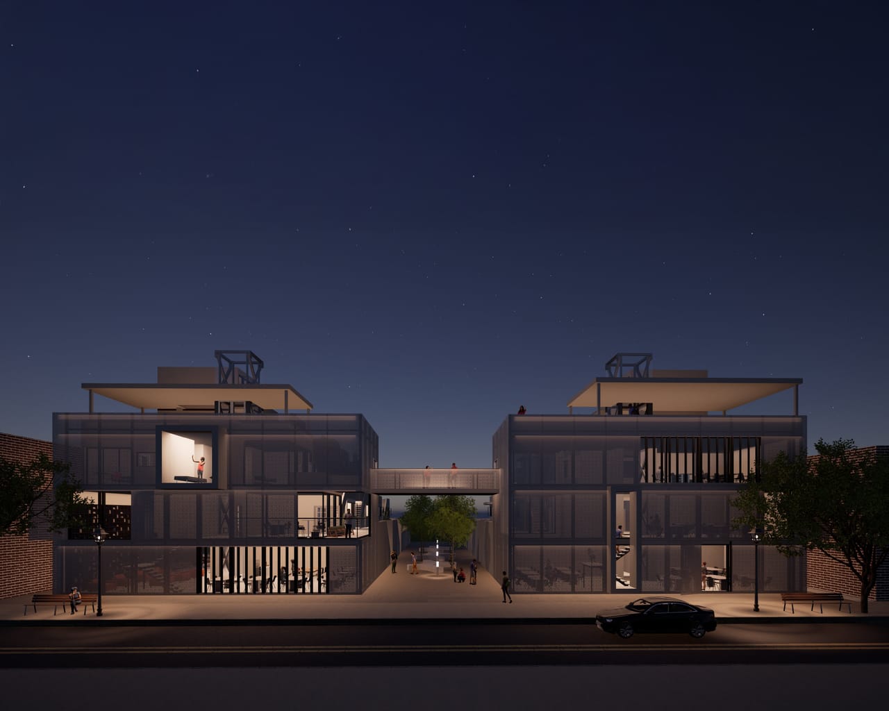 Two three-storey blocks with lit interiors and a footbridge between them, seen across the street under a starry sky
